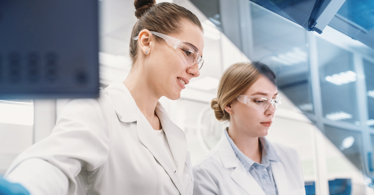 A team of two young laboratory technicians are checking their findings and engaging in chemical processes.