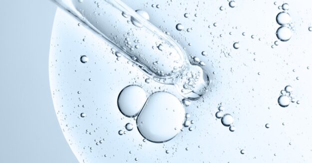 A close-up of a chemical element in liquid form with an instrument probing the inside of its bubbly mass.