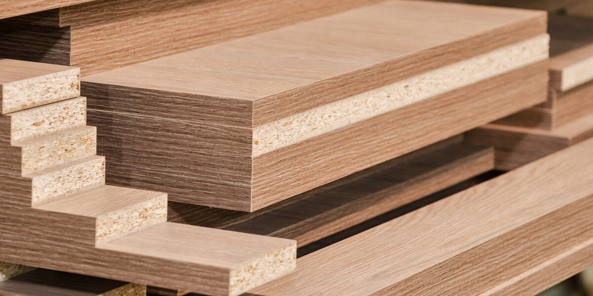 Multiple stacks of cut medium-density fiberboard (MDF) panels in different sizes, with finished and unfinished edges.