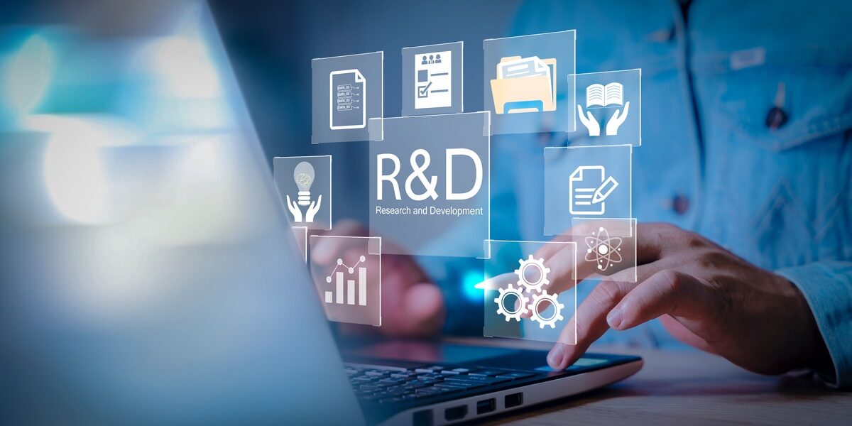 A man is sitting at a desk and typing on a laptop. There are graphics floating between the man and his laptop screen. A man is sitting at a desk and typing on a laptop. There are graphics floating between the man and his laptop screen.